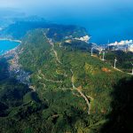 上空からみる佐田岬半島。3号機の再稼働が容認された伊方原発(右、3号 機は手前)と、5キロ圏内の集落(左)。真ん中に唯一の国道である197号 線(佐田岬メロディーライン)が走る。伊方町。2015年11月3日